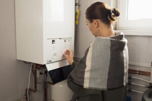 A woman reduces the power of the gas boiler in her home due to an energy crisis