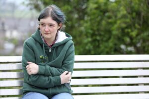 Serious woman sat on bench