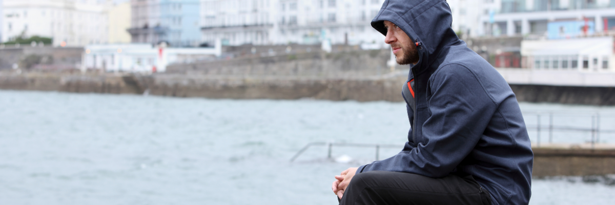 Serious man sat by water